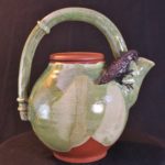 Stoneware teapot with a raven perched on the side